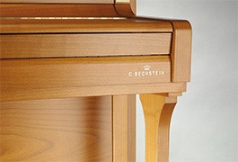 Piano acoustique droit C.BECHSTEIN 118 CONTUR Chêne Clair Détail d'un piano droit en bois clair.